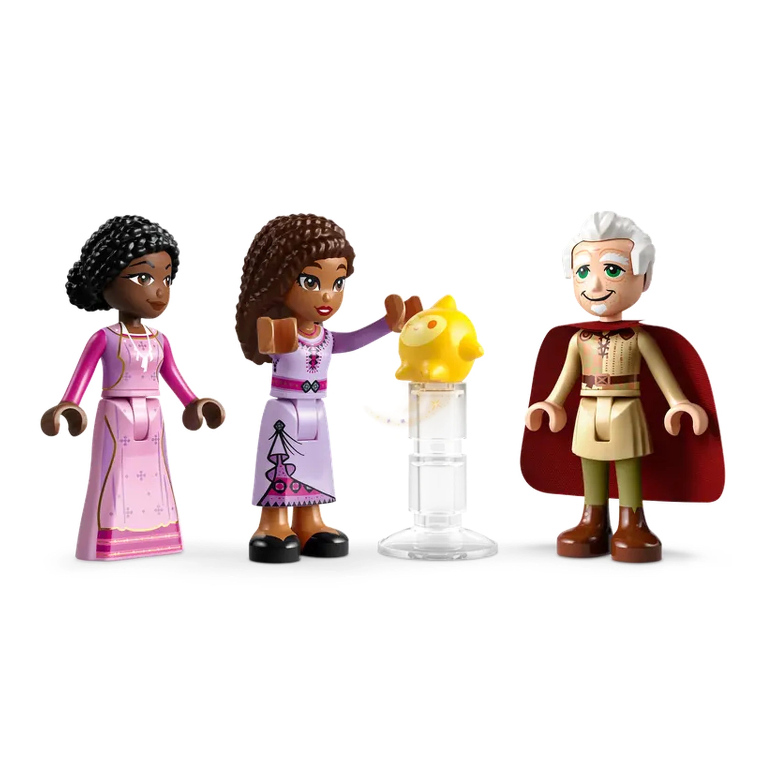 Three LEGO figures from Disney's "Wish": two girls in colorful dresses, one holding a yellow pig, and a smiling man in a cape.