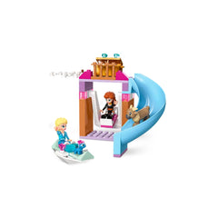 Elsa and Anna figures play with a dog on a colorful LEGO Frozen construction set, featuring a slide and a cozy play area.