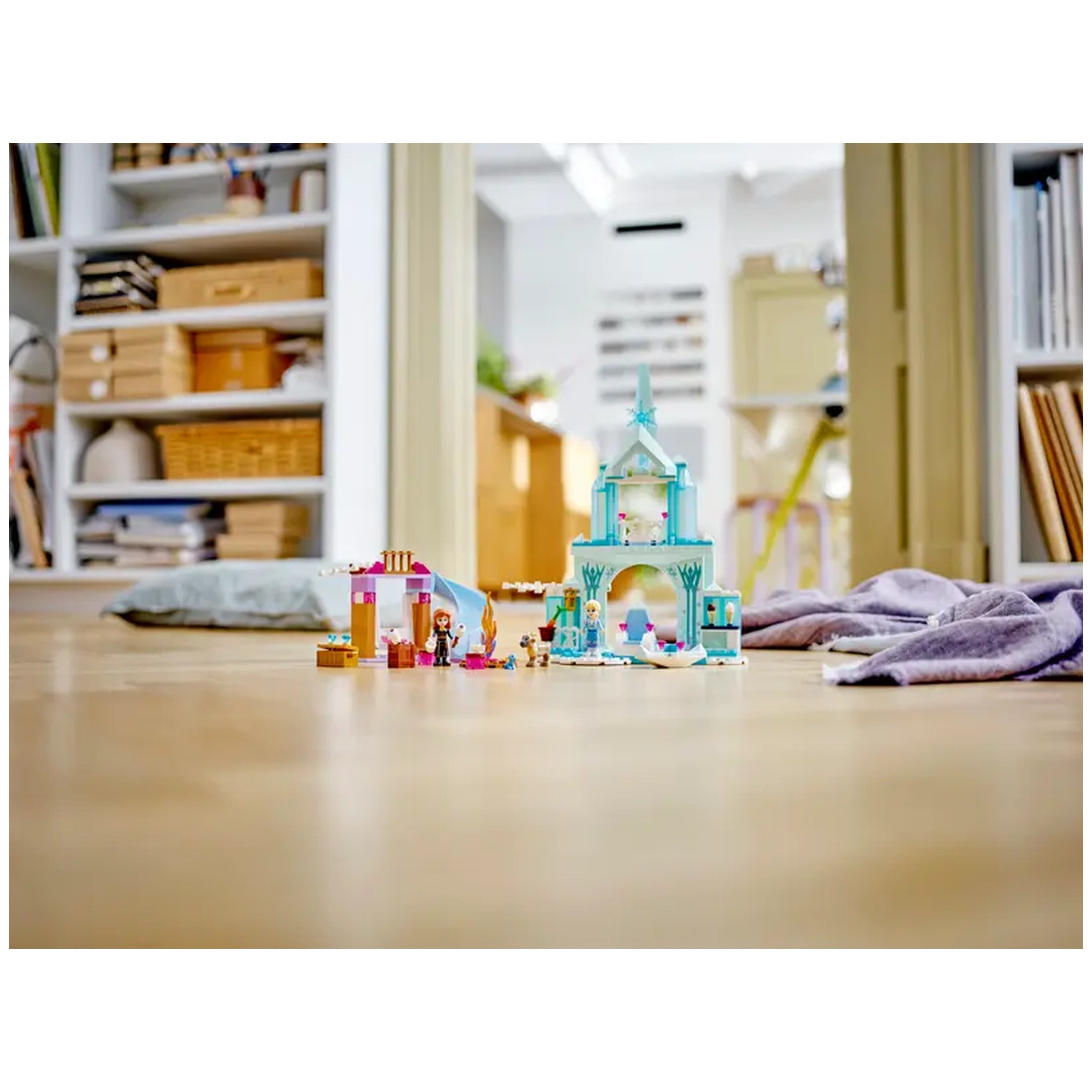 Colorful LEGO Disney Frozen Elsa's Castle set featuring characters Anna and Elsa, with a cozy kitchen and slide, on a wooden floor.