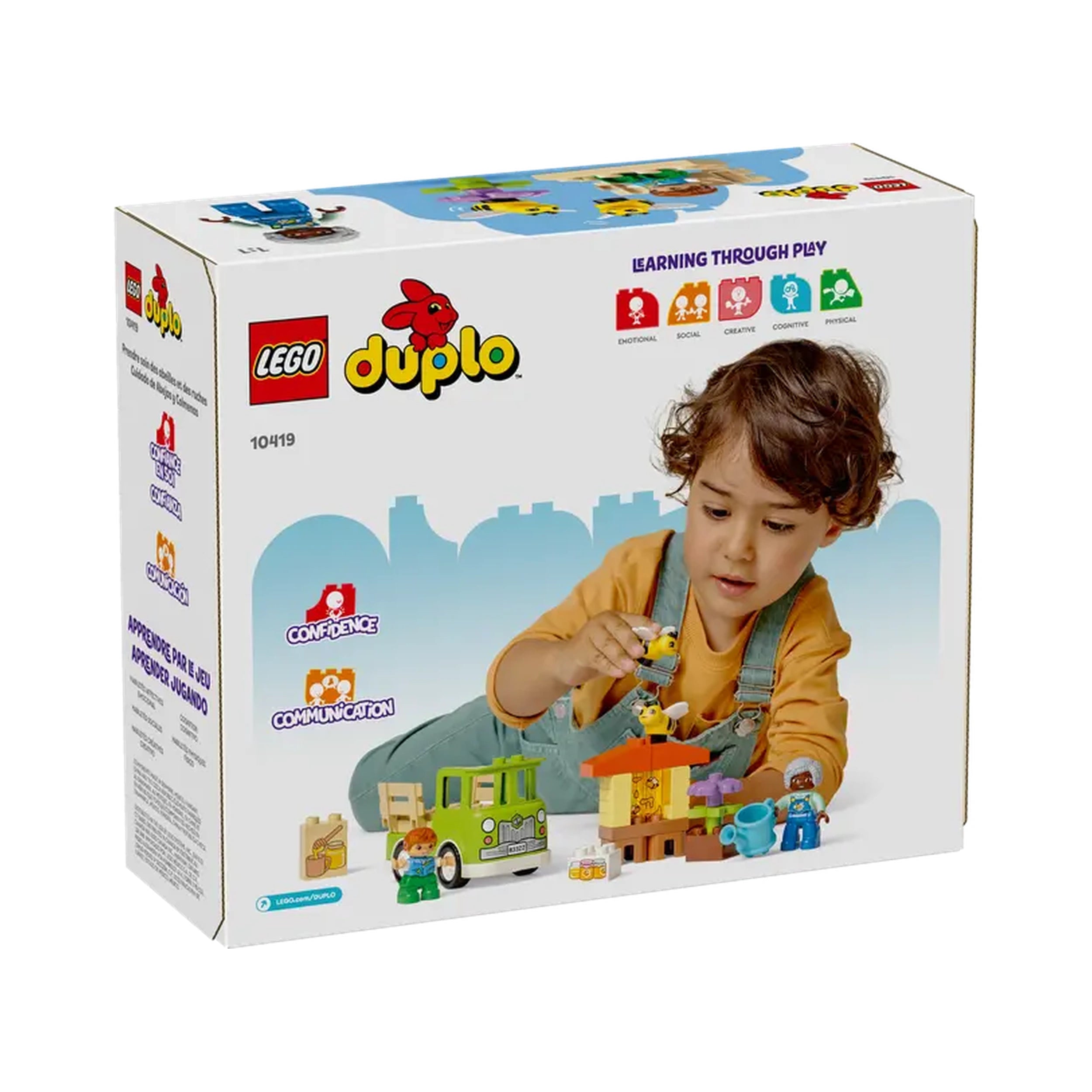 A child with curly hair plays with the LEGO® DUPLO® Caring for Bees set, featuring a beehive, truck, and flower elements, fostering creativity.