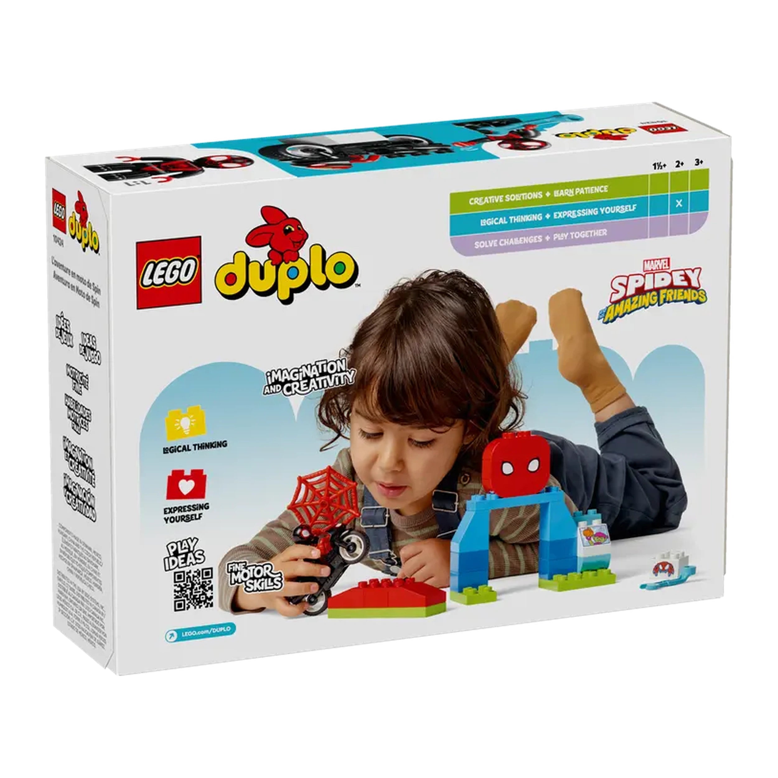 A young child lies on their stomach, focused on playing with the LEGO® DUPLO® Spin’s Motorcycle Adventure set, featuring a black motorcycle, Spider-Man figure, and colorful building elements. The child is engaged, stimulating their creativity and fine motor skills. The vibrant packaging showcases the set's educational benefits and connection to Spidey and His Amazing Friends.