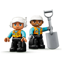 Two colorful LEGO® DUPLO® construction worker figures stand side by side, one holding a shovel. Each wears a safety vest and hat, with vibrant blue and orange colors enhancing their playful appearance.