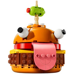 Vibrantly colored LEGO® Fortnite Durrr Burger construction set, featuring a smiling face with expressive eyes and a playful tongue sticking out, topped with a green olive on a toothpick.