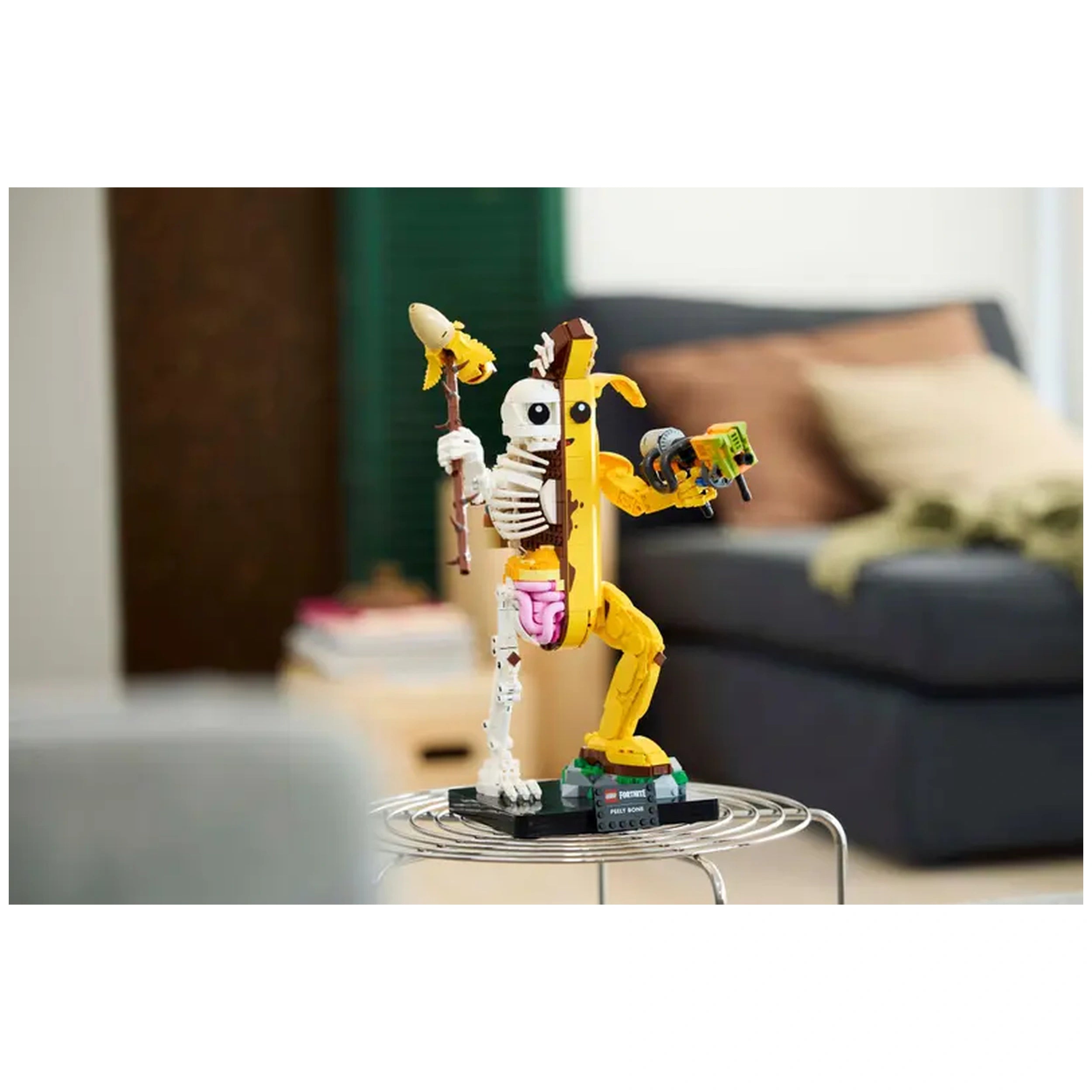 “LEGO® Fortnite Peely Bone construction set displayed on a wire stand, showcasing the whimsical yellow skeleton figure with movable limbs and accessories.”