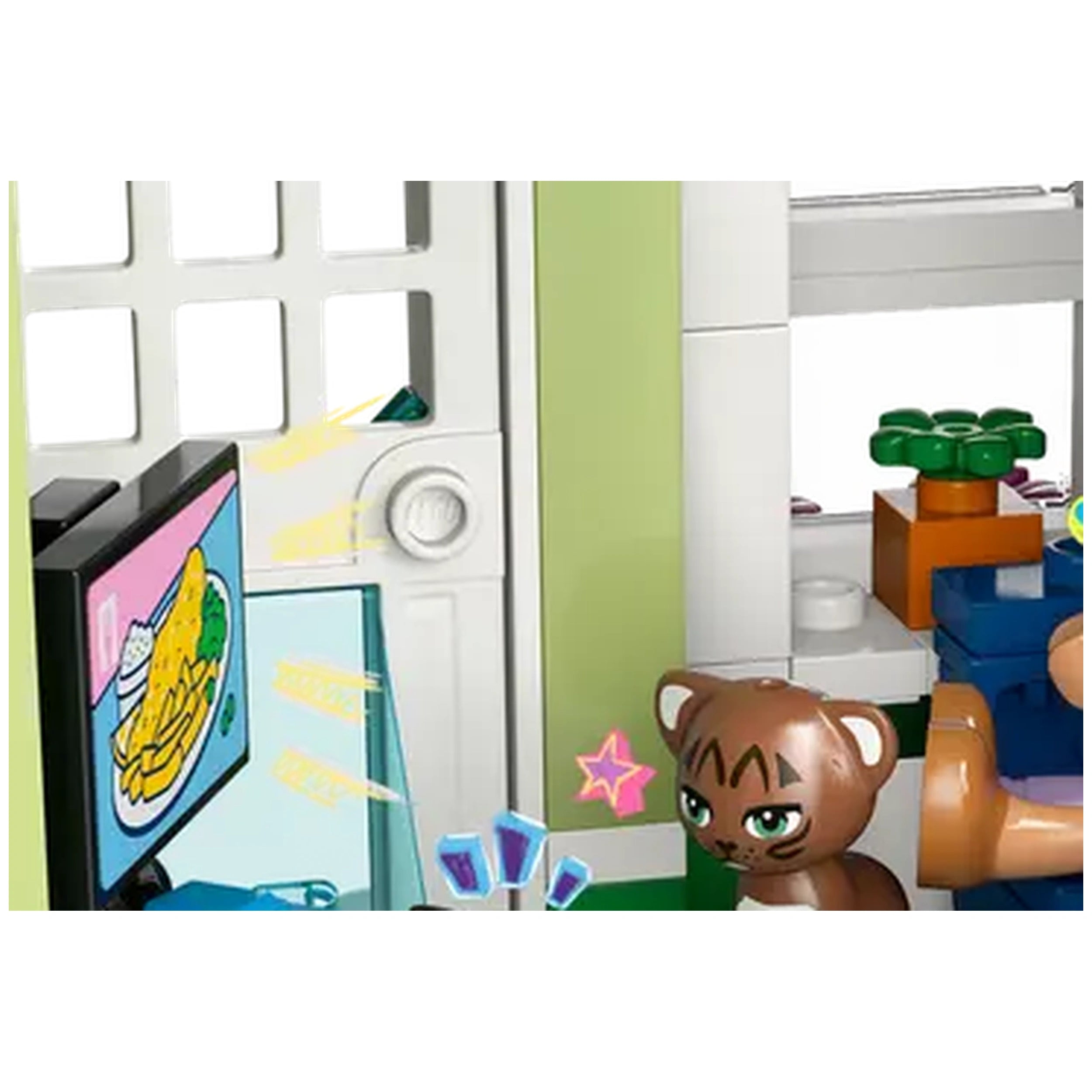 LEGO® Friends Heartlake City set features a colorful room with a small TV displaying food, a playful brown cat figure, and decorative plants.