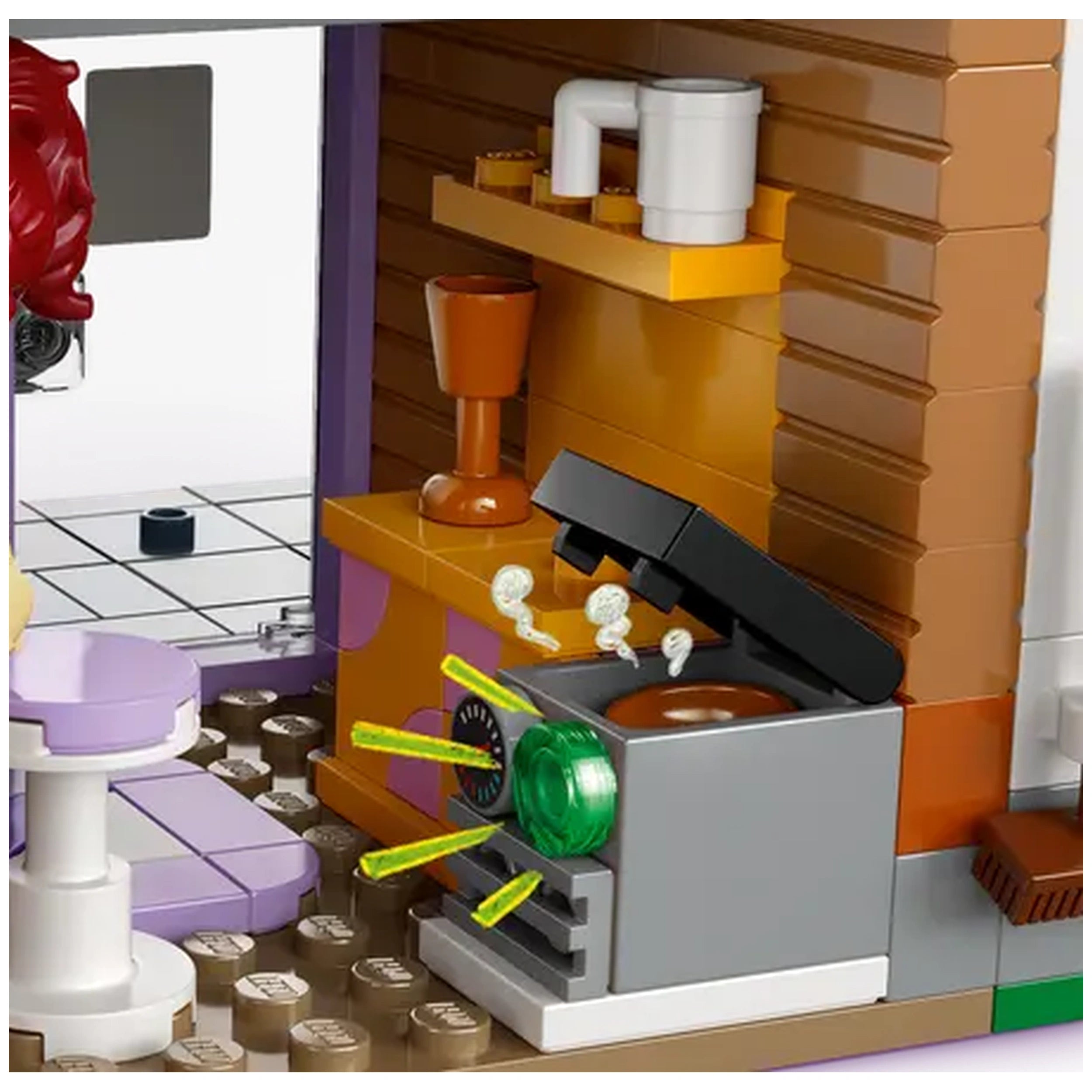 Brightly colored LEGO® Friends set featuring a modern kitchen with a stove, emitting green steam and white cooking smoke. A purple table and various kitchen items are visible, enhancing the lively atmosphere of this Heartlake City model.
