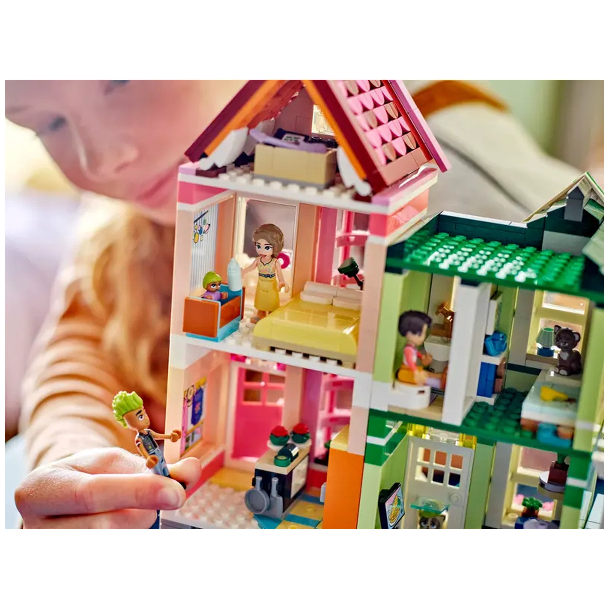 Colorful LEGO Friends Heartlake City Apartments set with three stories, featuring various rooms and characters engaged in playful scenarios.