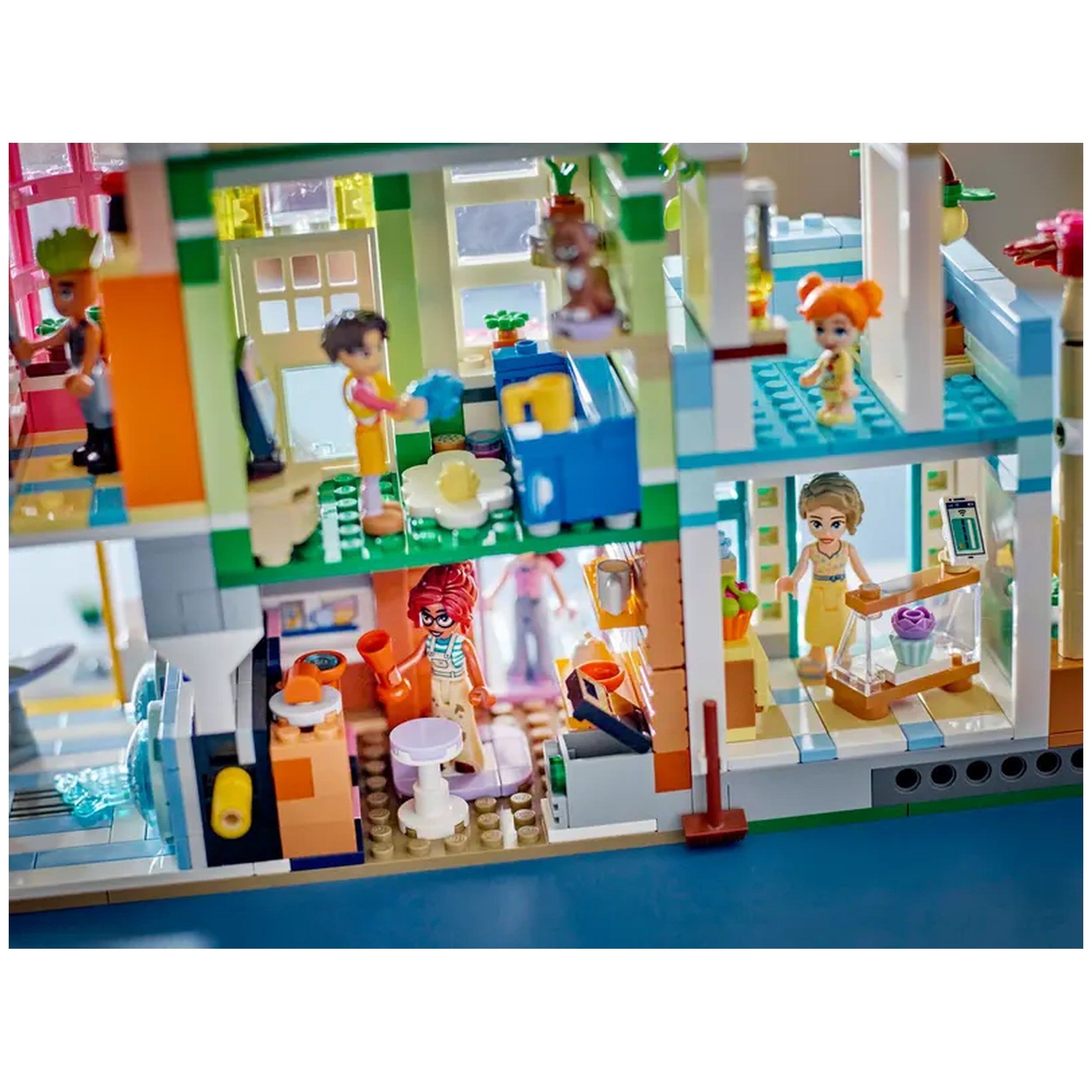 Colorful LEGO Friends Heartlake City Apartments set featuring miniature characters engaging in various activities in a vibrant neighborhood scene.