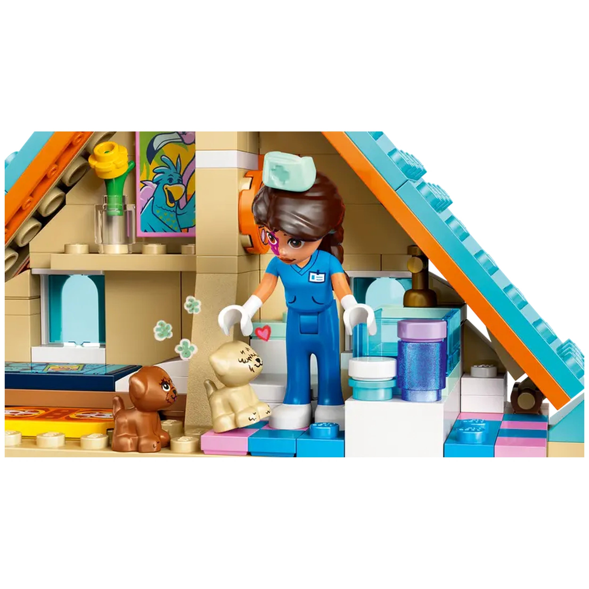 A LEGO® Friends vet clinic interior showcasing a female vet in blue scrubs caring for a small beige puppy, with a brown puppy nearby. Colorful veterinary tools and pet supplies are arranged on a countertop, creating a vibrant play scene.