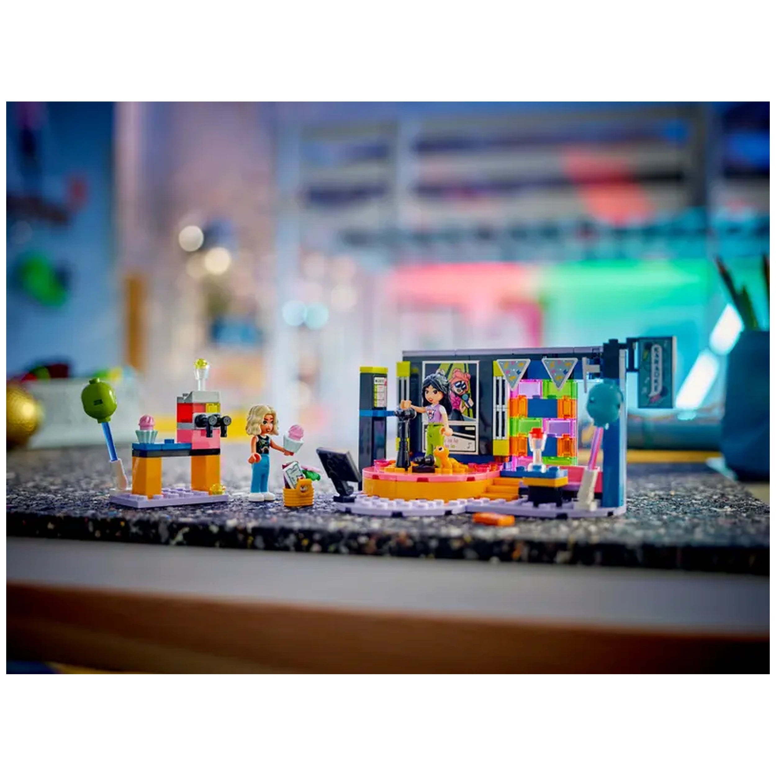 LEGO Friends Karaoke Music Party set featuring a colorful revolving stage, two characters singing, and a vibrant play area with a microphone and decor.
