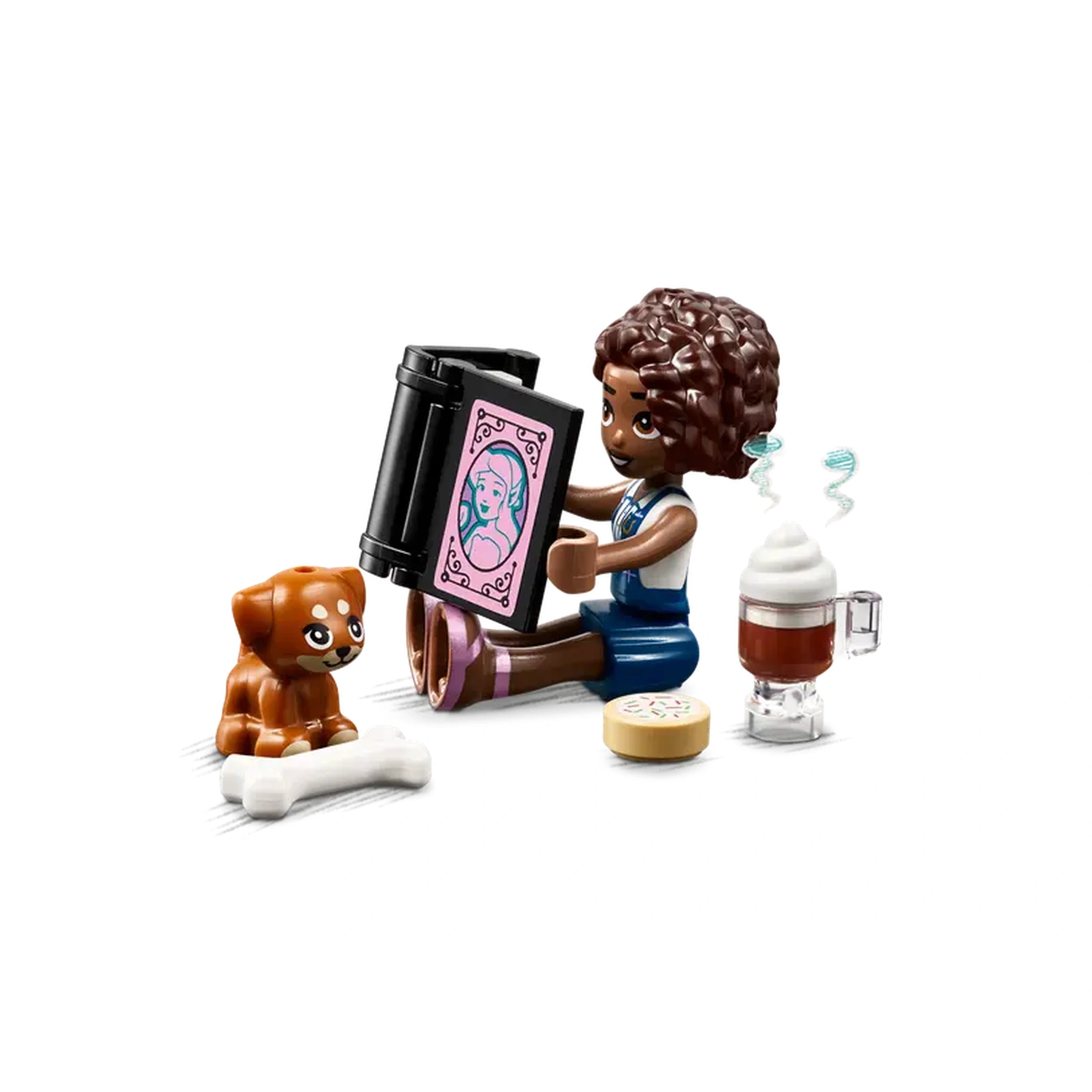 LEGO® Friends character Aliya with curly hair sitting on a floor, reading from a black book, beside her puppy Aira, a cookie, and a drink.