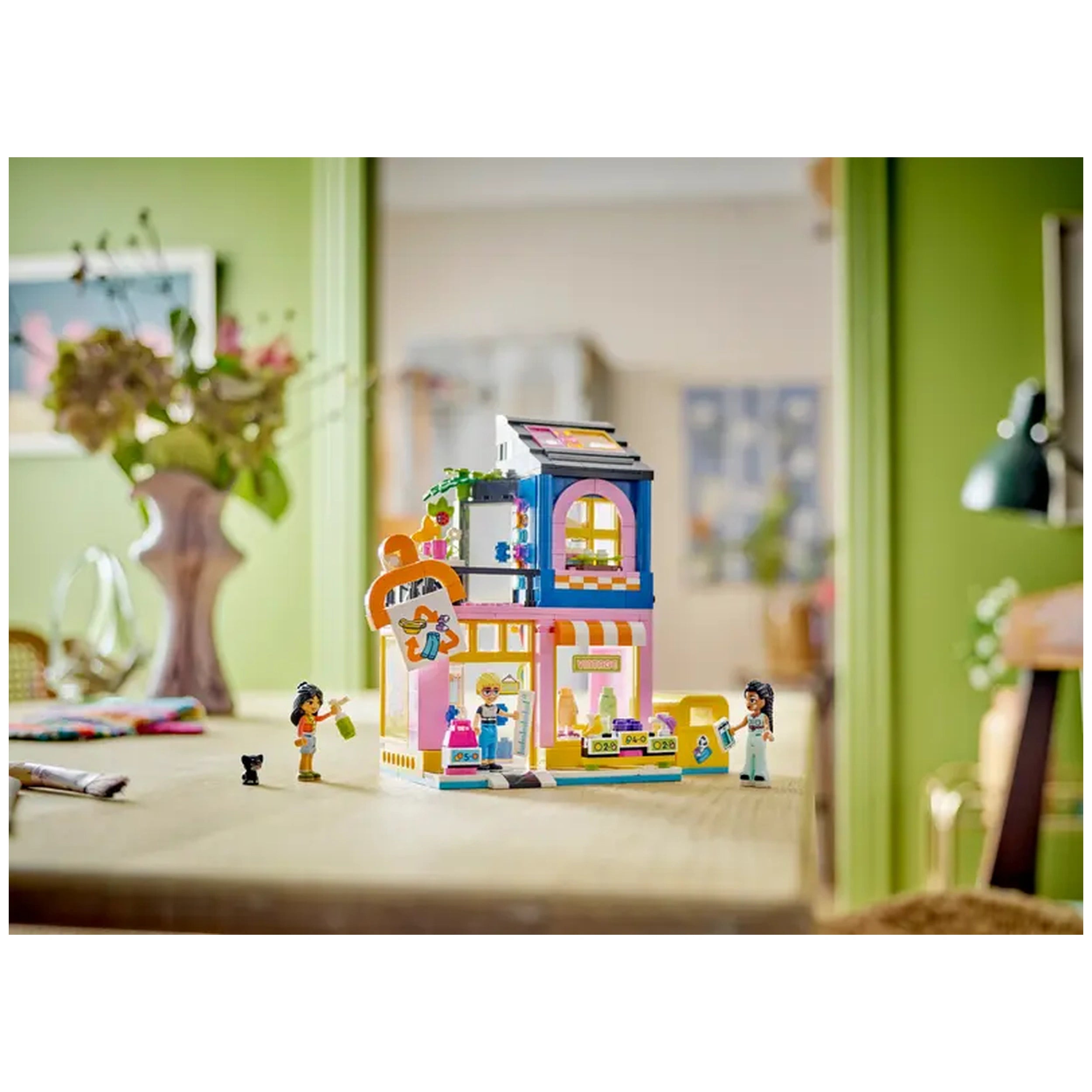 LEGO® Friends Vintage Fashion Store construction set with three characters and a cat, showcasing a colorful mini shop on a table.