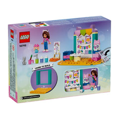 Gabby's Dollhouse LEGO set featuring a mini-doll with curly hair, paintbrushes, scissors, and vibrant colored blocks for creative play.