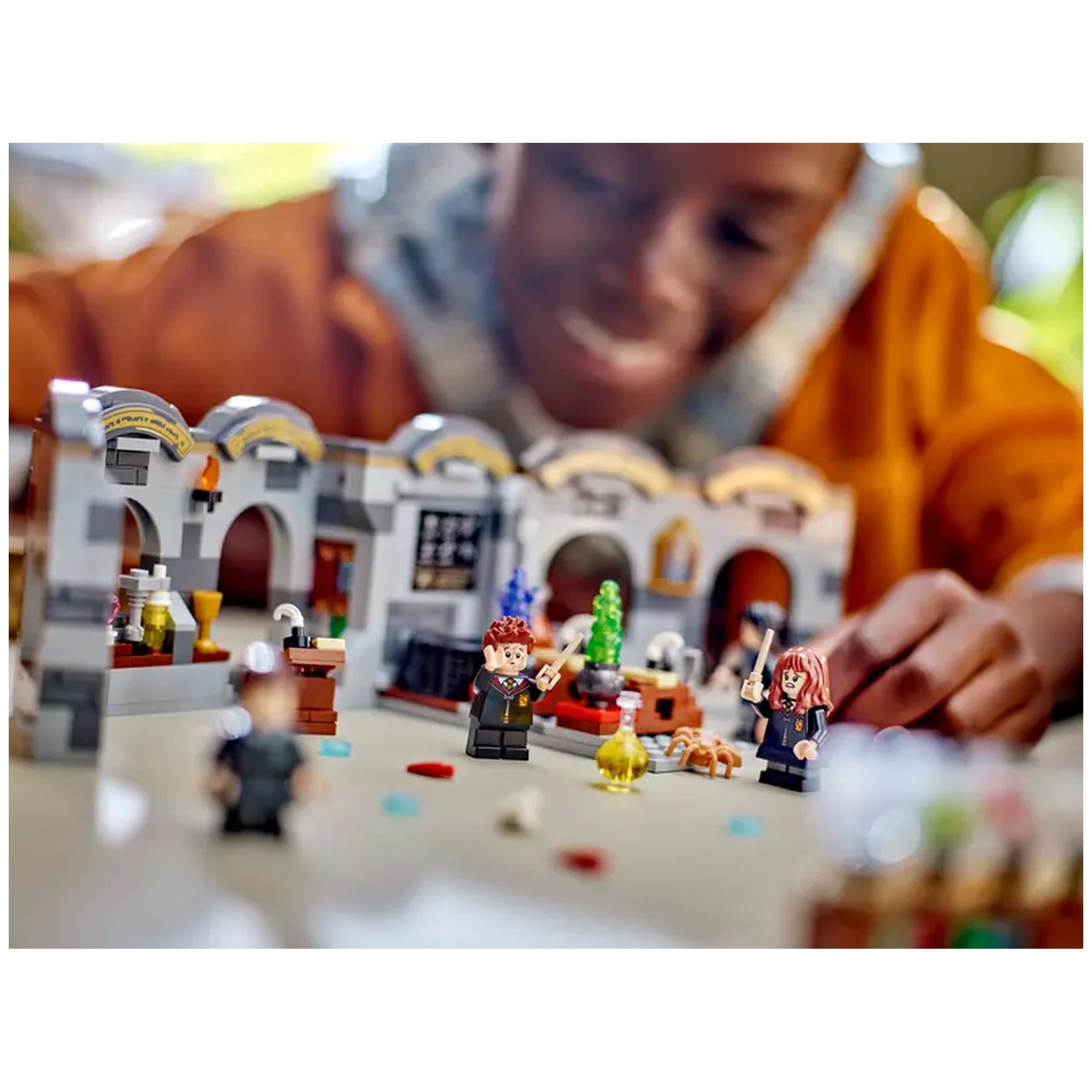 LEGO Harry Potter Hogwarts Castle: Potions Class set with minifigures of Harry Potter and Hermione Granger, featuring a detailed classroom backdrop with potion ingredients.
