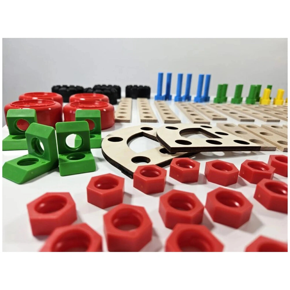 Colorful construction set pieces, including red wheels, green brackets, and wooden boards with holes, arranged on a white surface.