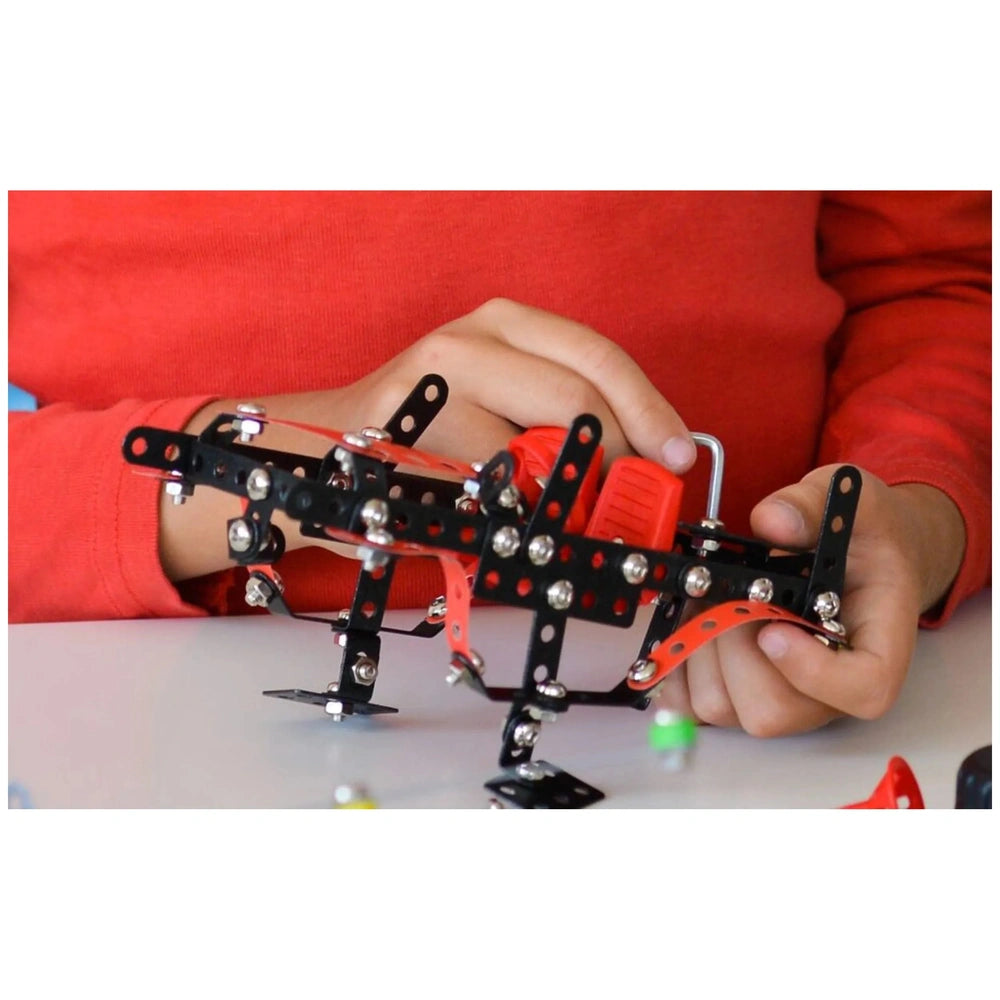 Child assembling Alexander Constructor Off-Road Machine with black and red metal pieces, enhancing creativity and manual skills.