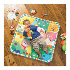 Benny the Puppy stuffed animal is held by a smiling child on a vibrant play mat, surrounded by a colorful wooden floor.