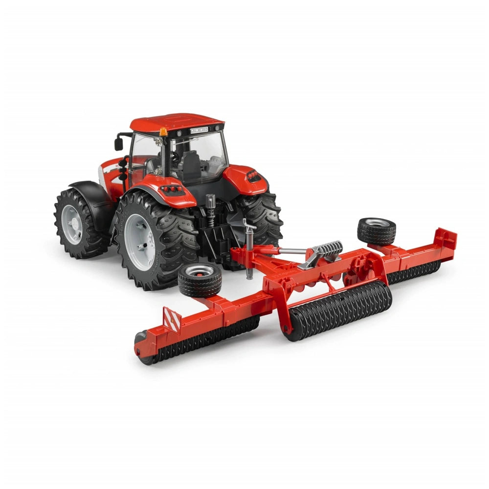 Red toy tractor with large black wheels attached to a red Cambridge roller, designed for imaginative agricultural play.