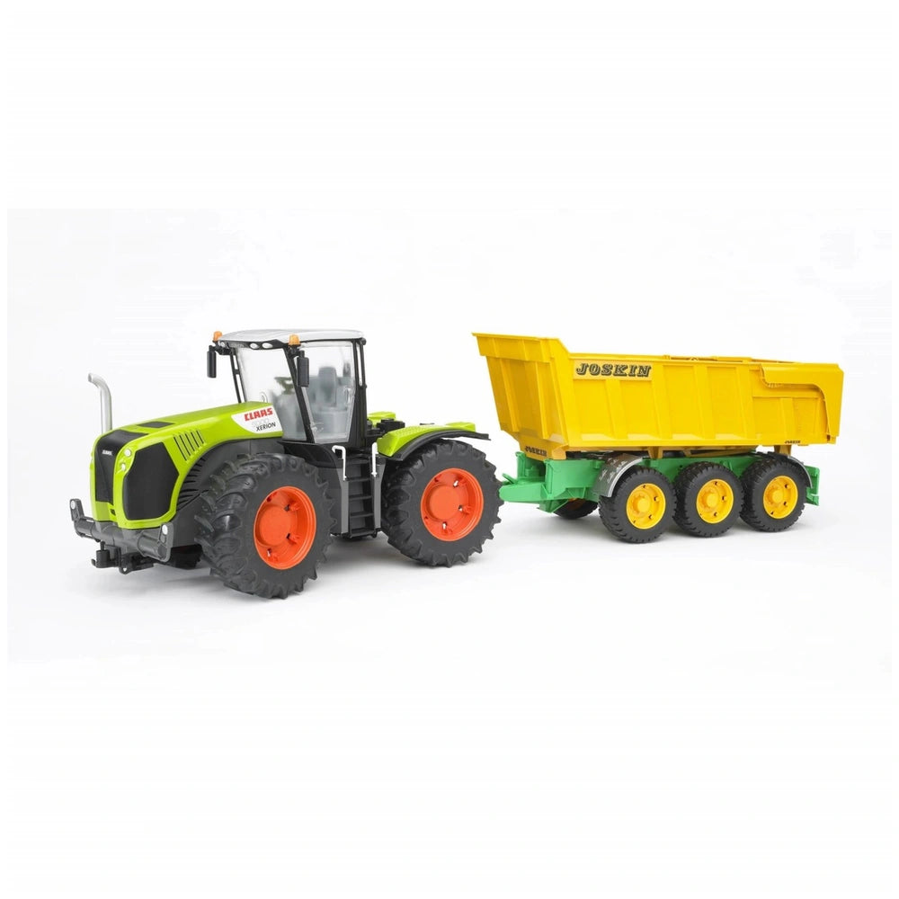 Green Claas Xerion 5000 tractor with a yellow Joskin trailer, featuring large orange wheels, on a white background.