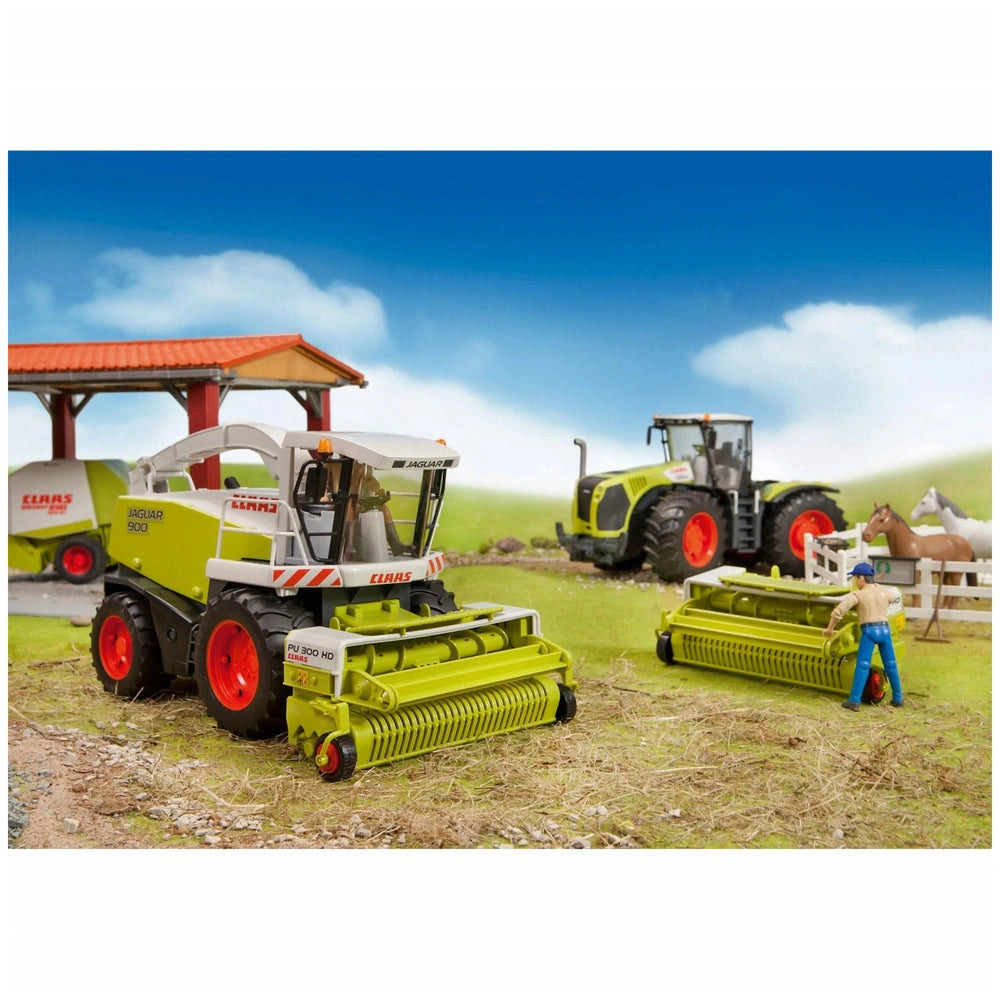Toy farm scene with two Claas tractors, a farmer figure, barn, and horses in a grassy field.