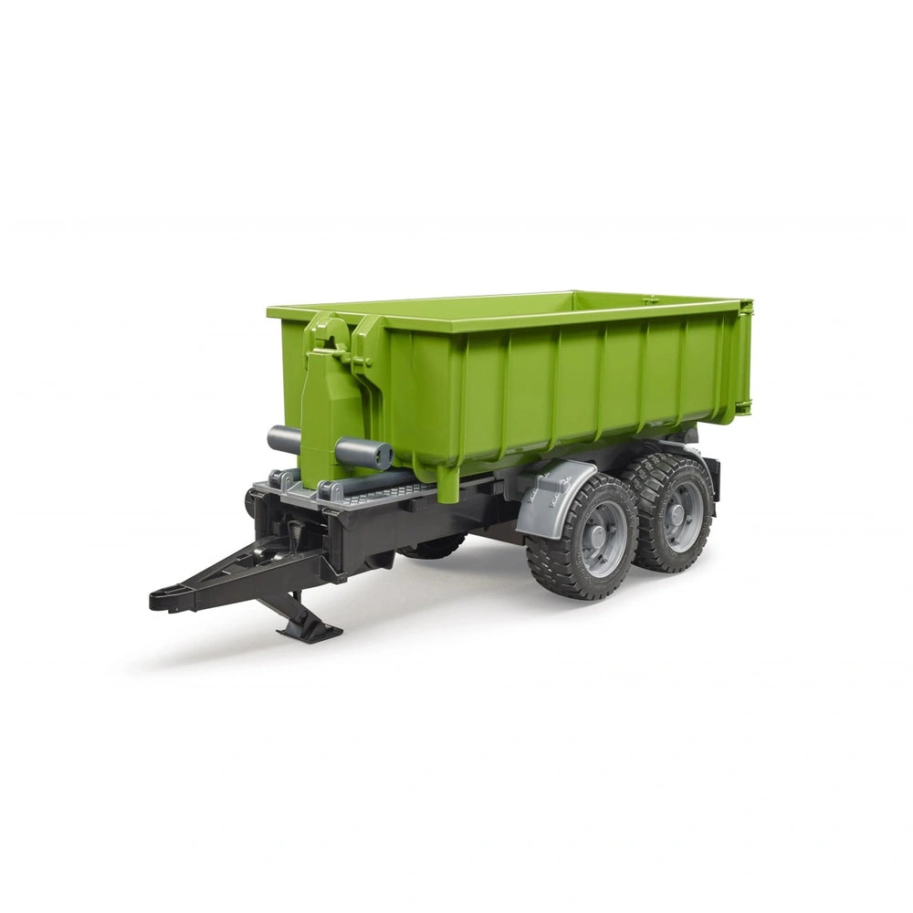 Green hook lift trailer toy with double wheels, tilting trough, and black hitch for tractors. Realistic agricultural design.
