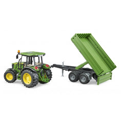 Green John Deere toy tractor with yellow wheels and a tipping trailer attached.