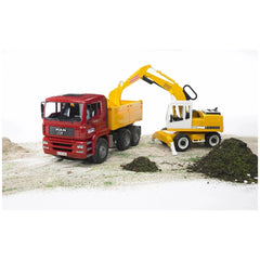 Red MAN TGA construction truck with yellow Liebherr excavator on sandy terrain, digging and loading soil.