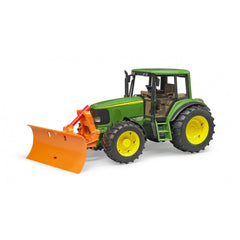 Green toy tractor with large yellow wheels and an orange plow blade attached in the front, designed for realistic play.