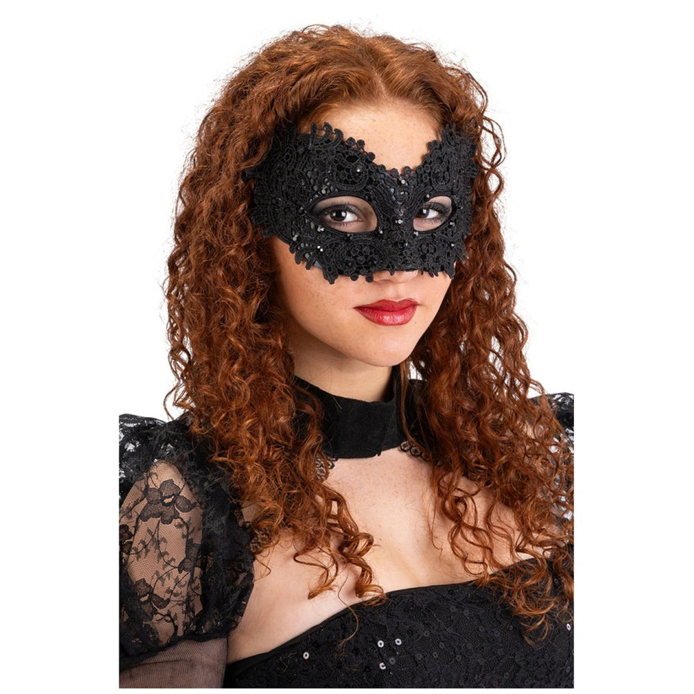 Black lace mask with rhinestones on a cardboard backing, worn by a woman with curly red-brown hair and bright red lipstick.