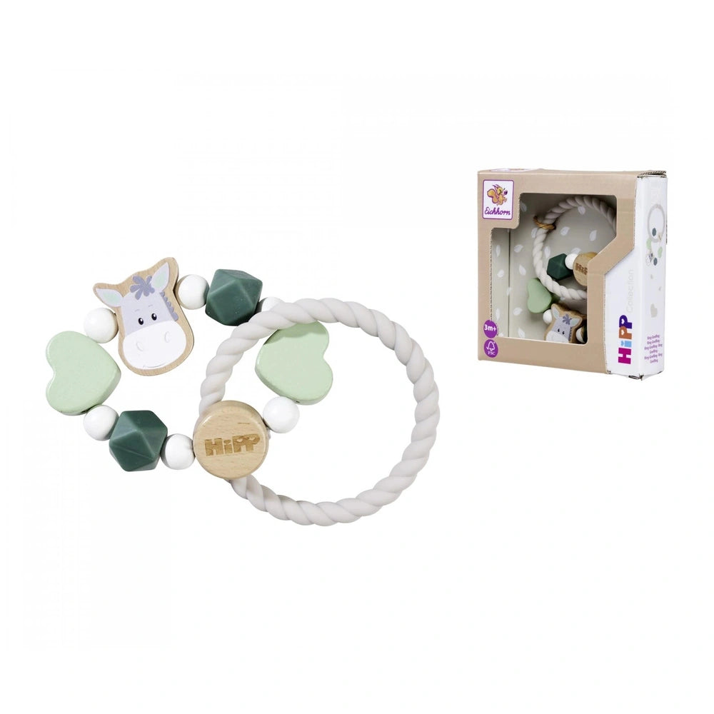 Baby HiPP Grapper plush toy horse with a white body, brown mane, and green tail alongside a cardboard toy box.