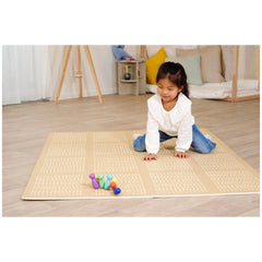 Eichhorn bowling game set up on a light-colored mat, with a young girl focused on playing in a cozy indoor setting.