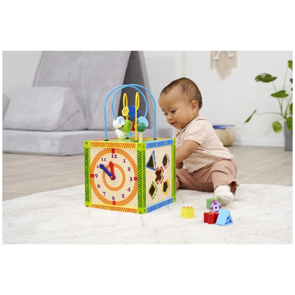 Eichhorn Color Little Play Center features a young child engaged with a colorful block structure with a clock face on a fluff