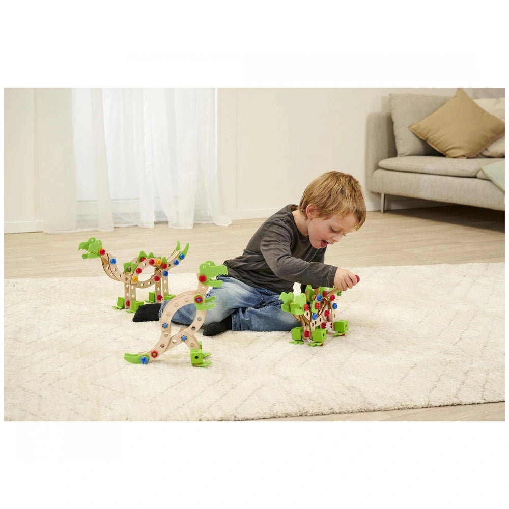 Eichhorn Constructor Dinosaur construction set with colorful beads, played by a child on a white shaggy rug.