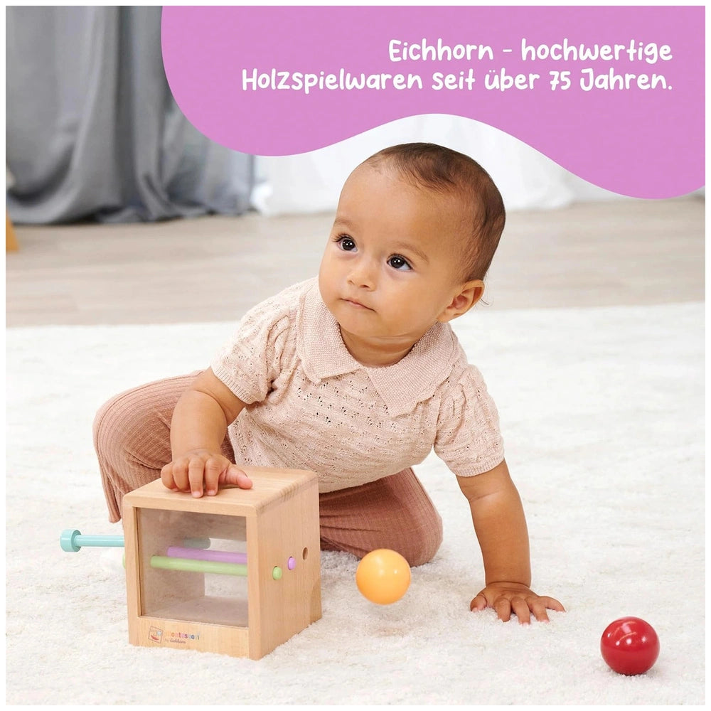 Eichhorn Montessori interactive educational toy set with a baby exploring a colorful wooden toy and balls on a carpeted floor
