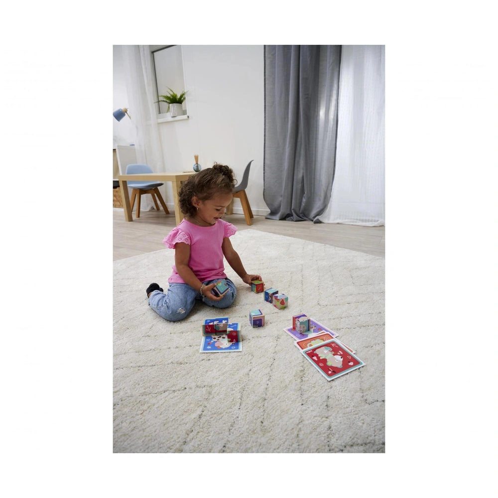Eichhorn Picture Cube Friends - child playing with colorful blocks on a light carpet in a minimalist room.