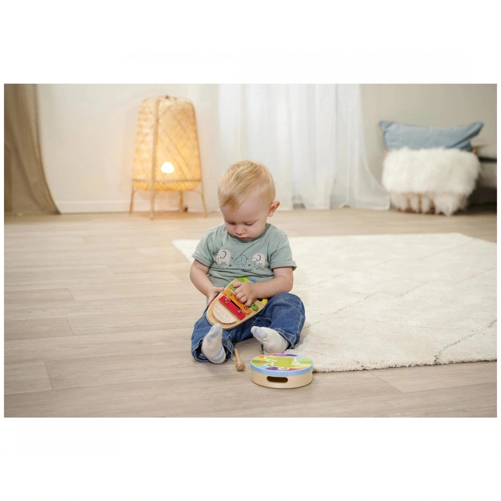 Eichhorn Wooden Drum and Xylophone Music Set shown with a toddler focused on the colorful xylophone in a cozy indoor setting.
