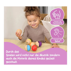 Eichhorn Wooden Music Balls - 6 colorful wooden toys engaging a young child in skill-building playtime activities.