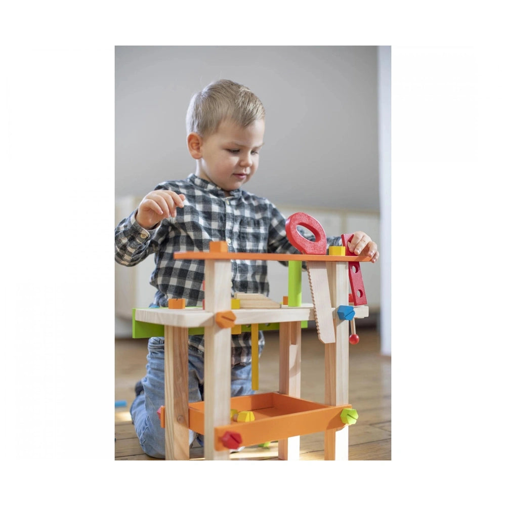 Eichhorn Work Bench featuring a child playing with a colorful wooden construction set on the floor.