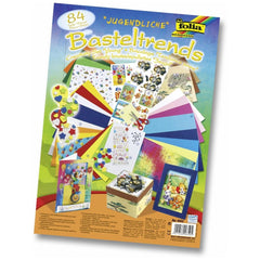 Folia Creative Bricolage Set with 84 pieces including colorful boxes, paper, fabric, scissors, ribbons, and stickers.