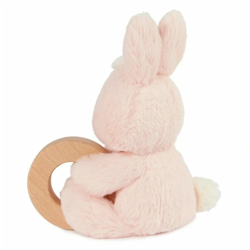 Plush pink bunny ring rattle sits on a smooth wooden surface, showcasing its soft texture and cute design.