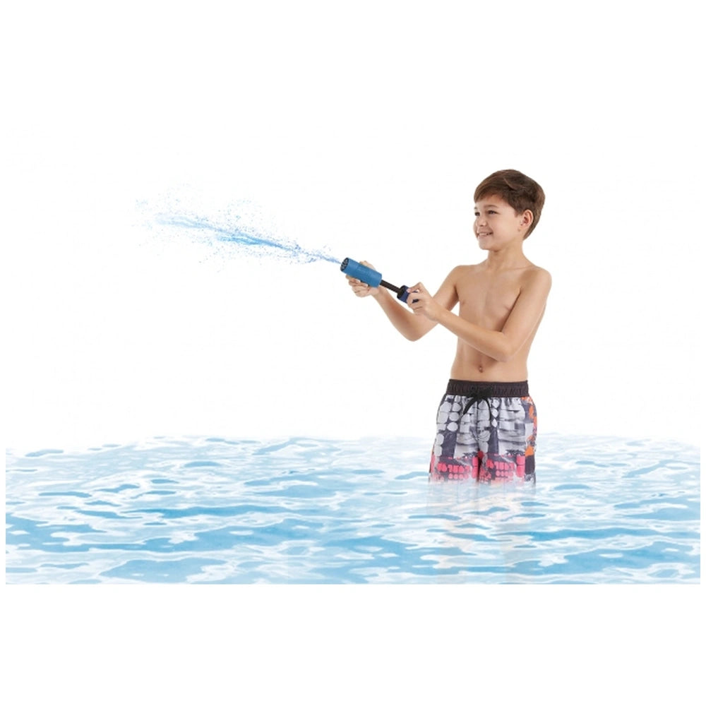 Happy People Foam Shooter Mini Pocket Liquidator in boy's hand, splashing in blue water while wearing multicolored swim trunk