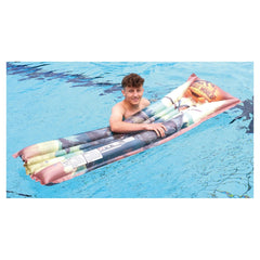 Happy People Jurassic World air mattress in shades of pink, blue, and yellow, with a smiling person on a blue water surface.