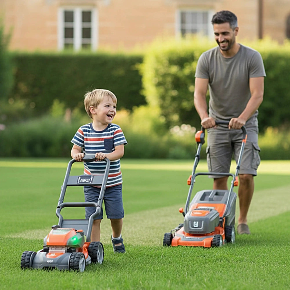 Husqvarna toy lawn mower in orange and gray, with two children playing on green grass, one in blue and one in gray attire.