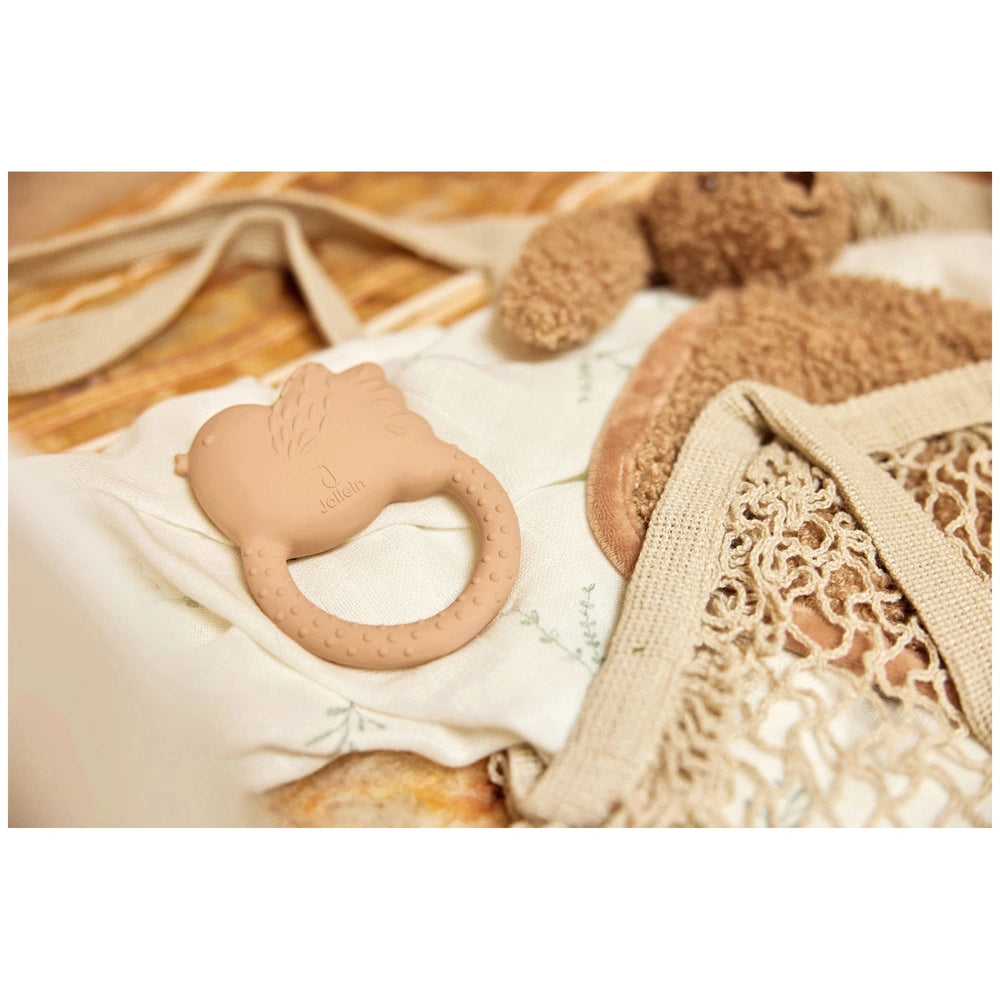 Jollein pacifier cloth bunny in soft fabric with a pacifier marked "JJ" and a textured light-colored blanket.