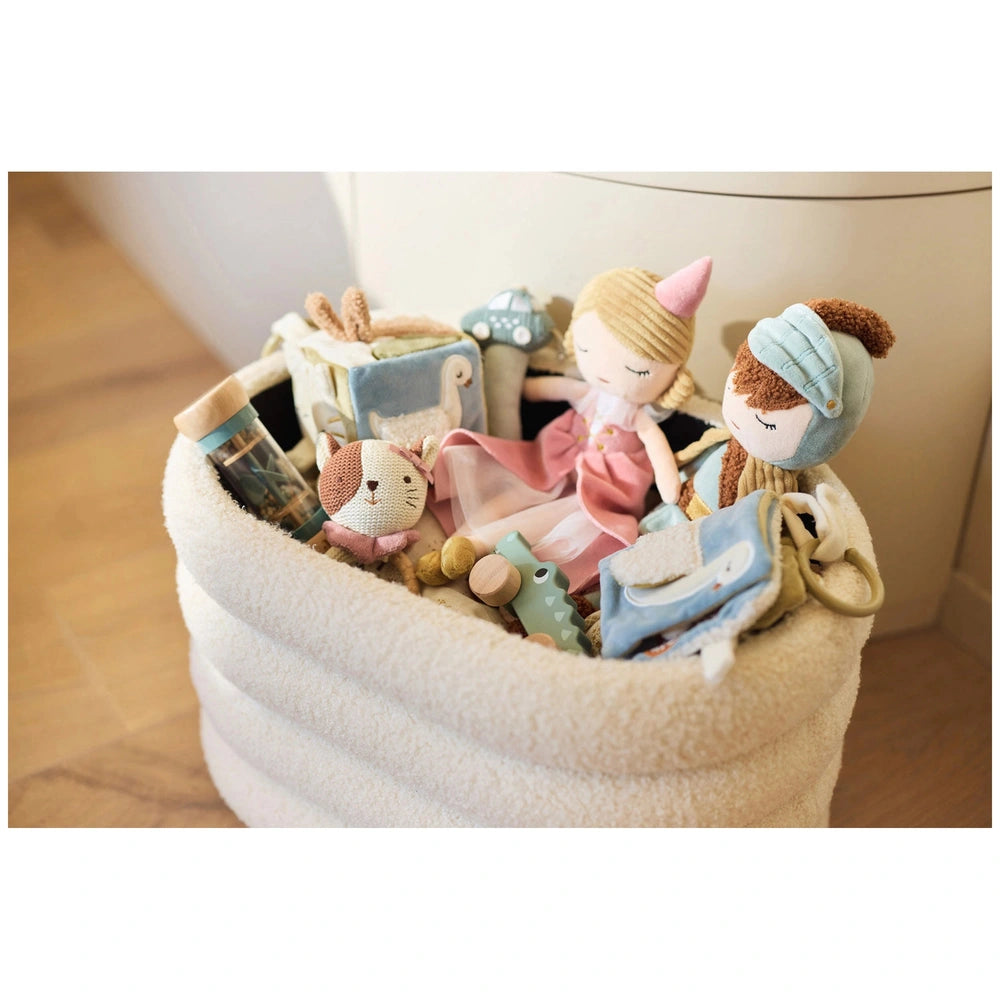 Jollein Soft Activity Book with colorful plush toys, including animals, arranged in a white basket on a wooden floor.
