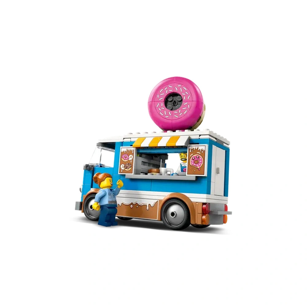 Colorful LEGO City Donut Truck with a giant pink donut on top, featuring a service window and minifigure serving a customer.