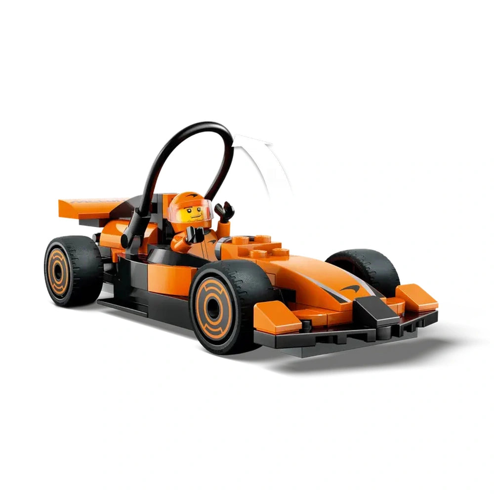 LEGO® City F1® Driver minifigure inside an orange McLaren race car, featuring sleek design and detailed tires, ready for adventure.