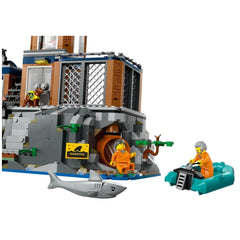LEGO® City Police Prison Island set features two minifigures in orange jumpsuits near a rocky prison, a warning sign, a shark, and a green escape boat.