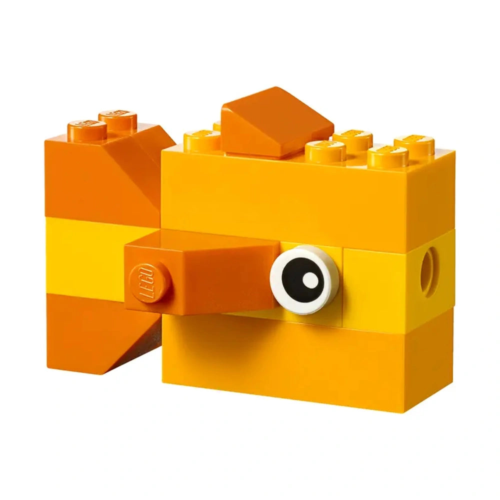 A vibrant orange LEGO building block shaped like a fish, featuring a black and white eye and a small triangular fin on top.
