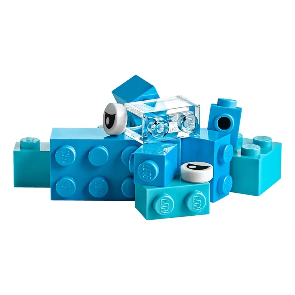 A colorful assortment of blue LEGO bricks, including different shapes and sizes, some featuring cartoonish eyes, arranged playfully on a white background.